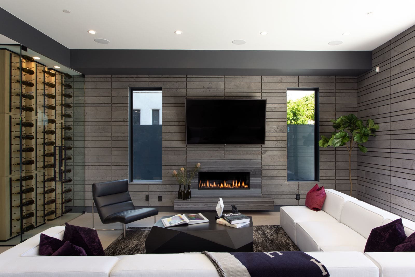 Norstone Platinum Planc Large Format Tile used as a background feature wall behind a large tv and smooth stone fireplace